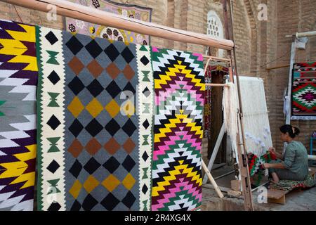 Femme qui tisse à l'atelier de tissage Kilim à Itchan Kala, Khiva, Ouzbékistan ; Khiva, Ouzbékistan Banque D'Images