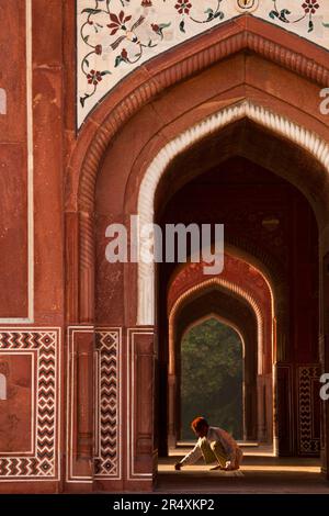 Homme squats dans le Taj Mahal ; Agra, Inde Banque D'Images
