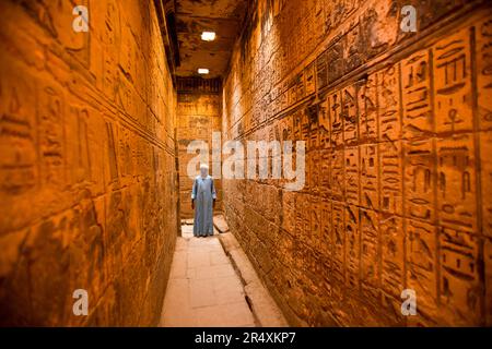 L'homme se tient dans un couloir de Medinet Habu ; Louxor, Egypte Banque D'Images