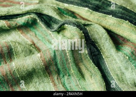 Texture du tissu du foulard vert. Tissu torsadé grossier, arrière-plan. Banque D'Images