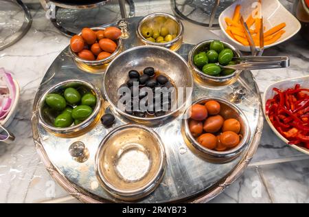 Diverses olives, olives dans un bol, assortiment d'olives servi au buffet. Olives du Caucase, olives colorées, olives colorées servies Banque D'Images