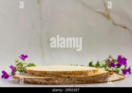 Podium vide d'une coupe d'arbre et avec des fleurs violettes sur fond clair. Disposition pour la présentation du produit, des cosmétiques ou de la parfumerie Banque D'Images