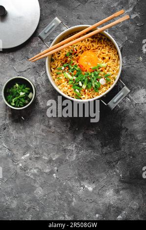 Nouilles instantanées de style coréen, Shin Ramyeon ou Ramyun avec œuf, Scallion et bouillon, soupe de nouilles sur fond sombre Banque D'Images