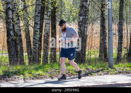 Homme en train de courir le marathon de la ville d'Helsinki à Ramsaynranta dans le quartier de Munkkiniemi à Helsinki, en Finlande Banque D'Images