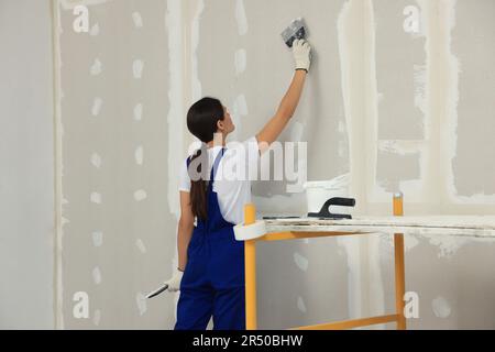 Mur de plâtrage avec couteau à mastiquer à l'intérieur Banque D'Images