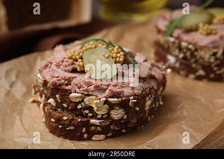 Délicieux sandwichs de livrewurst avec concombre mariné et moutarde sur table, en gros plan Banque D'Images