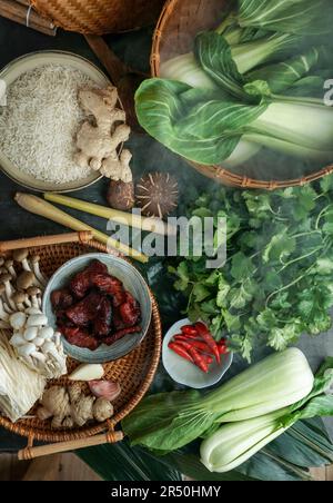 Ingrédients pour la cuisine asiatique dans un cuiseur vapeur de bambou (riz, champignons asiatiques, shiitake, Shimeji, pak choi, feuilles de bambou, gingembre, piment) Banque D'Images