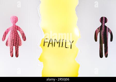 Concept de divorce. Ballon avec mot famille entre hommes et femmes silhouettes, vue à travers les trous dans le livre blanc Banque D'Images