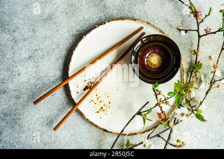 Table de printemps avec baguettes décorées de branches de cerisier en fleurs Banque D'Images