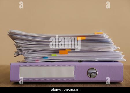 Pile de documents et dossier de bureau sur table en bois sur fond marron Banque D'Images