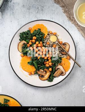 Salade de kale végétalienne avec quinoa, champignons et tranches d'orange Banque D'Images