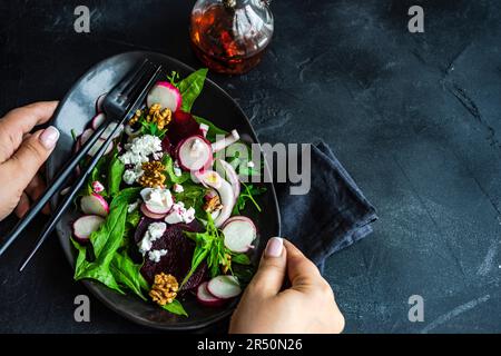 Salade saine aux épinards et aux betteraves servie dans un bol avec fromage feta et noix Banque D'Images