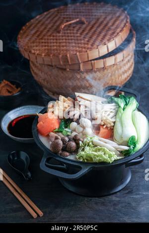 Pot chaud au chou chinois et aux champignons, cuit dans un bouillon crémeux et copieux de lait de soja Banque D'Images