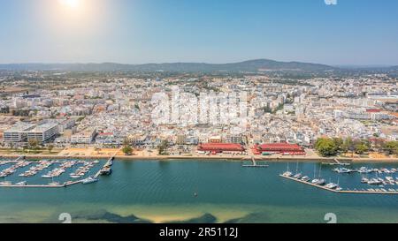 Vue aérienne de la ville touristique portugaise de pêche d'Olhao avec une vue sur le parc marin de Ria Formosa. Port de mer pour les yachts et le soleil sur les montagnes Banque D'Images