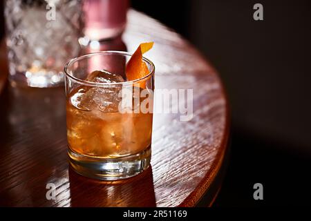 Cocktail avec glace et zeste d'orange sur la table Banque D'Images