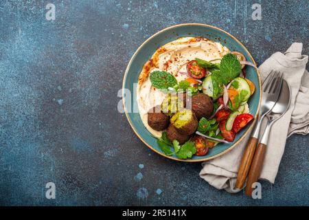 Repas arabe avec frit de falafel, houmous, salade de légumes avec cilantro vert frais et feuilles de menthe (Moyen-Orient) Banque D'Images