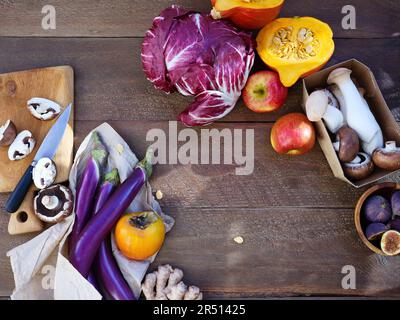 Vue de dessus légumes et fruits de saison, ingrédients végétariens sains sur fond de bois Banque D'Images