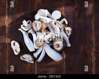 Vue de dessus divers champignons coupés sur une assiette Banque D'Images