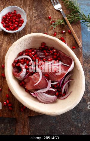 Hareng mariné dans du vin rouge, avec des graines de grenade et de l'oignon rouge Banque D'Images