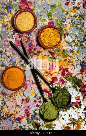 Assiette avec curry et deux cuillères noires avec stévia et ail sauvage sur fleurs séchées Banque D'Images