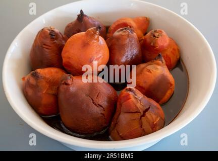 Des quinces rôties au four dans du sirop de vin rouge épicé à la cannelle jusqu'à une recette de Maggie Beer Banque D'Images