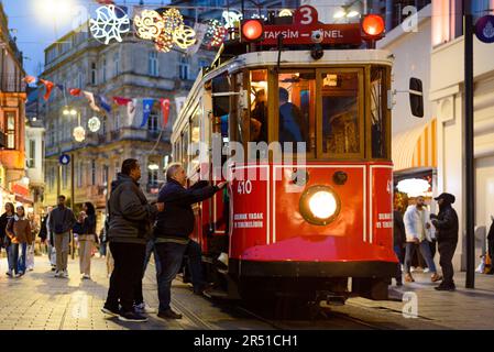 Istanbul, Turquie - 20 avril 2023 : la nuit, on voit des gens monter à bord d'un tramway traditionnel dans la rue Istiklal, dans le centre-ville. Transports publics à ISTA Banque D'Images