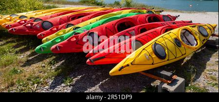 Rangées de kayaks tiré sur une plage de galets après un jours de canotage Banque D'Images