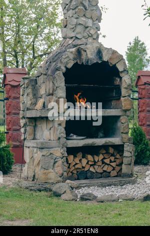 Gril au feu de bois construit de rochers en pierre, grillades dans le jardin. Banque D'Images