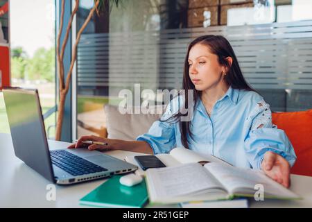 Jeune femme d'affaires travaillant en ligne au bureau à l'aide d'un ordinateur portable. Femme d'âge moyen enseignant à la recherche d'informations assis à un bureau. Banque D'Images