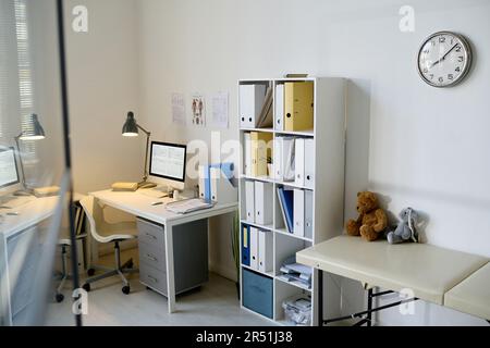 Bureau moderne du médecin pédiatre avec lieu de travail et placard avec dossiers Banque D'Images