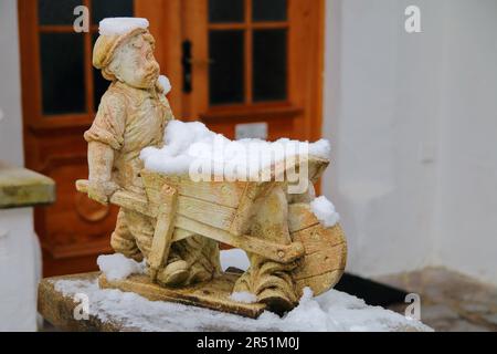 La photo a été prise en Allemagne, dans la rue de la ville de Garmisch-Partenkirchen. La photo montre une statuette drôle d'un garçon avec une brouette, Banque D'Images