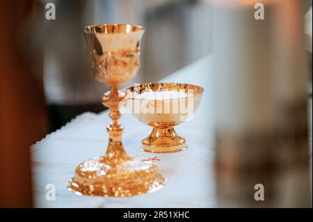 Capturer le symbolisme sacré : une image du vaisseau Chalice et eucharistique lors d'une Messe capitale dans un cadre d'église intemporel Banque D'Images