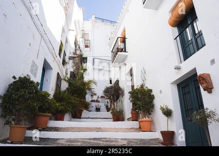 De dessous de beaux bâtiments résidentiels blancs avec des balcons sur les montagnes avec des marches pavées et des rampes avec des plantes en pot placé sur la rue Banque D'Images