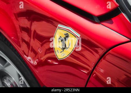 Vue latérale d'une voiture de sport de luxe rouge Ferrari avec l'autocollant noir du logo cheval sur le corps, pas de personne Banque D'Images