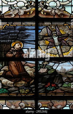 Saint François d'assise recevant les stigmates du Christ sur la croix sous la forme d'un Séraphin à six ailes. Représenté en vitraux dans une église dédiée à Sainte Élisabeth de Hongrie, le Begijnhofkerk Sint Elisabeth, qui sert le Béguinage ou Begijnhof, une maison religieuse fortifiée, à Bruges, Flandre occidentale, Belgique. Banque D'Images