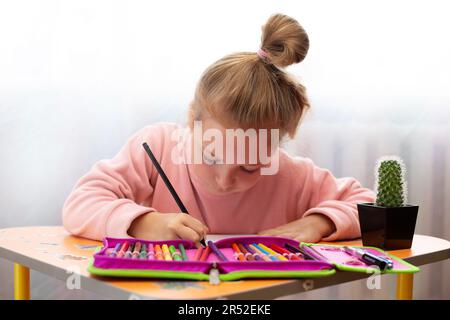enfant fille qui fait ses devoirs écrire et lire à la maison Banque D'Images