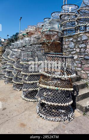 Des casiers à homard empilés contre le mur du port à Brixham Banque D'Images