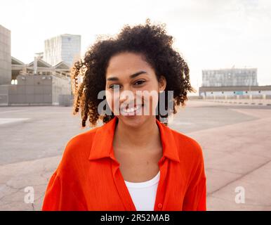 Jeune femme afro-américaine souriante et joyeuse regardant un appareil photo. Femme d'émotions positives Banque D'Images