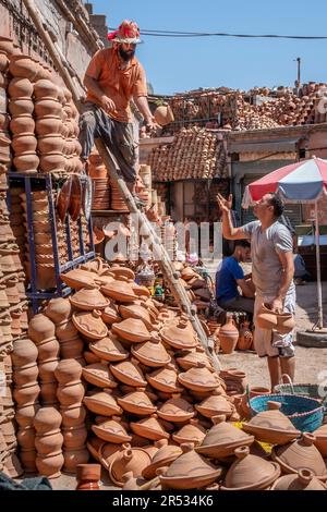 Un potier empile ses marchandises à Souk el Khemis, Marrakech, Maroc Banque D'Images