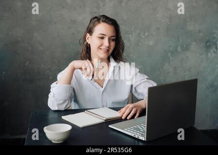 Enseignement numérique : une femme d'affaires élégante ou un enseignant participant à une visioconférence à partir d'Office, mettant l'accent sur le travail en ligne et les concepts d'enseignement à distance. Banque D'Images