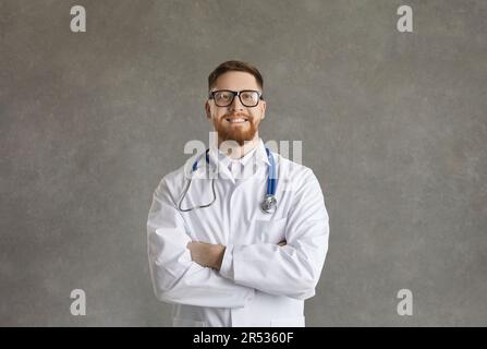 Portrait d'un homme souriant et confiant sur fond de béton gris. Banque D'Images