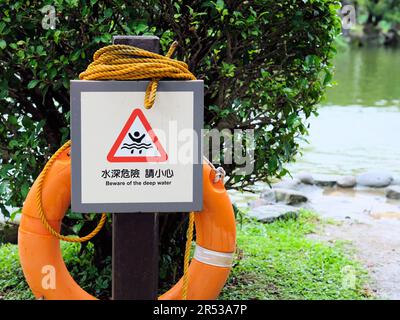 Attention au panneau d'avertissement Deep Water à Yunhan Pond au Chiang Kai-Shek Memorial Hall à Taipei, Taiwan ; corde orange et sauveur. Banque D'Images