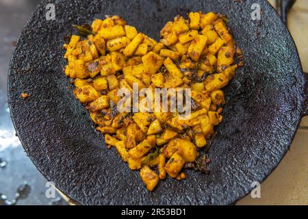 La teinte dorée de la pomme de terre frite dans une poêle à frire est une joie culinaire, vous donnant envie de savourer les accompagnements croustillants et moelleux à chaque bouchée. Banque D'Images