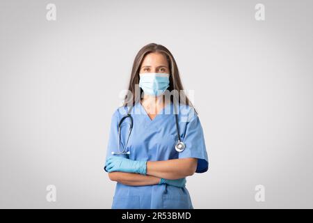 Portrait d'une femme européenne senior médecin en uniforme bleu et stéthoscope sur son cou, doc portant un masque facial Banque D'Images