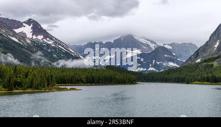 Mt. Gould and Angel Wing - vue panoramique des nuages de tempête survolant Mt. Gould et Angel Wing sur les rives du lac SwiftCurrent, parc national des Glaciers. Banque D'Images