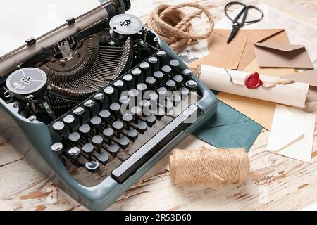 Composition avec machine à écrire vintage, rouleau et enveloppes sur table en bois blanc Banque D'Images