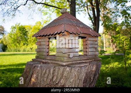 Mangeoire en bois pour les animaux sauvages vivant dans le bosquet. Un mangeur pour écureuils et autres rongeurs fait dans une forme de maison dans le parc. Banque D'Images