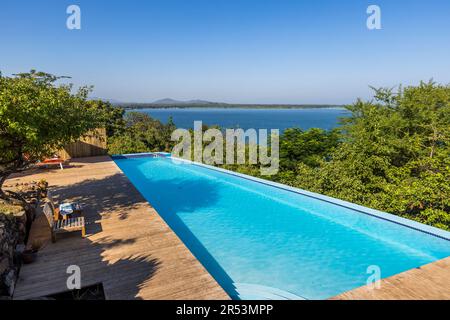 Piscine surplombant le lac Malawi à Cape Maclear. Pumulani Lodge, Robin Pope Safaris, sur les rives du lac Malawi, Cap Maclear, dans le parc national du lac Malawi. Kasankha, Malawi Banque D'Images