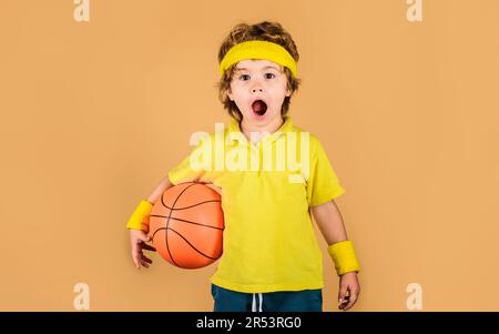 Sport, forme physique et mode de vie sain. Petit garçon avec ballon de basket-ball. Sport pour les enfants. Petit ballon de basket-ball. Un enfant surpris Banque D'Images