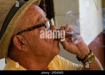 Vinales, Cuba - 21 mai 2018: Un vieil homme cubain dans un chapeau de cow-boy fume un cigare qu'il roula Banque D'Images